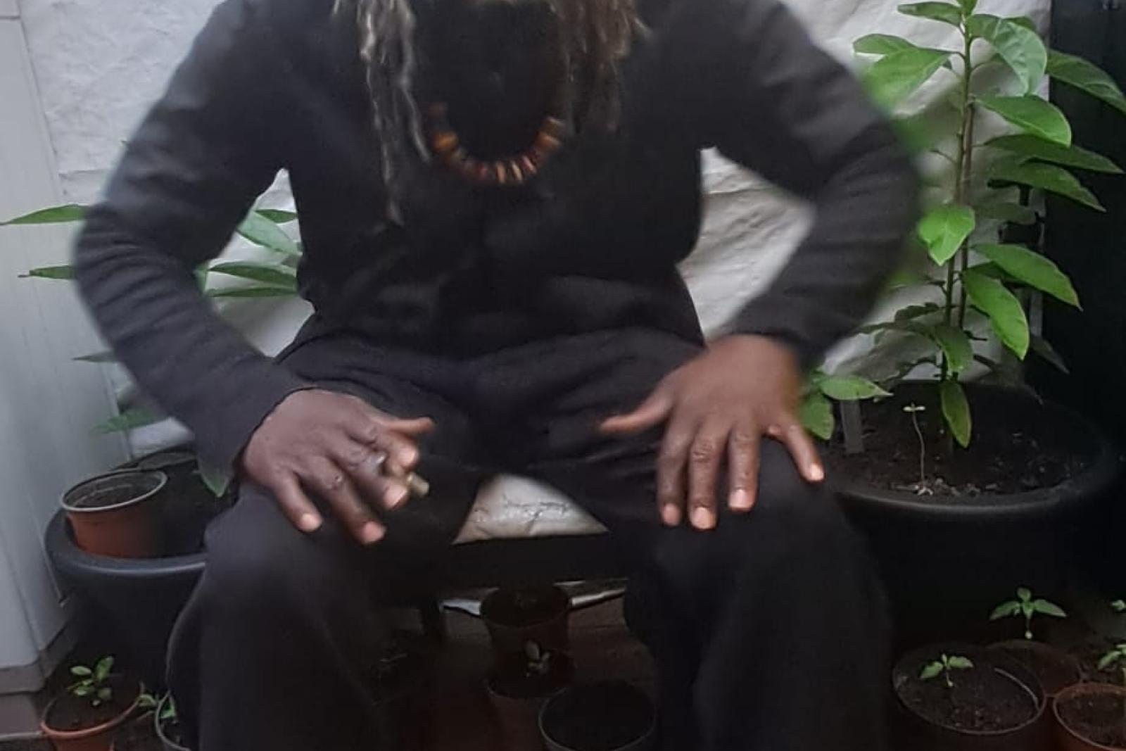 Fyah Mawi leaning forward while seated in a dark suit.