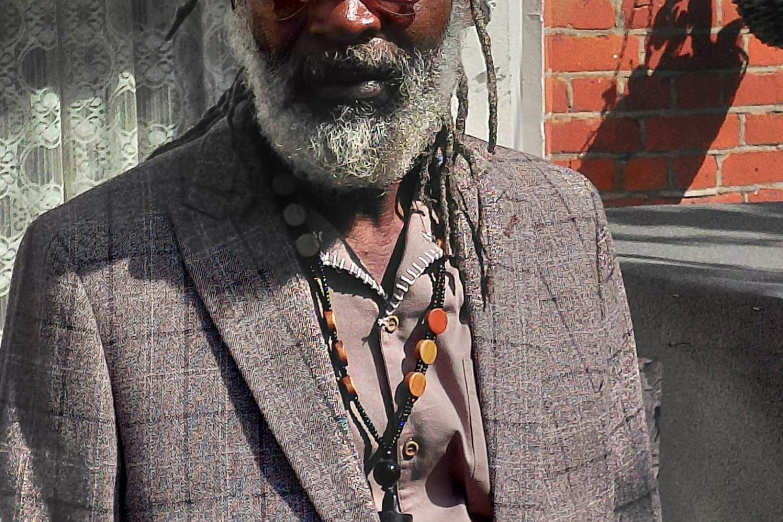 Portrait of Fyah Mawi in a checked jacket and cap.