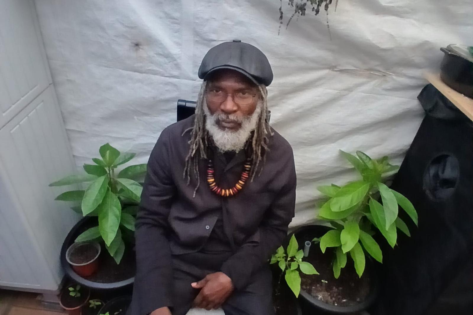 Fyah Mawi seated with crossed legs in a dark suit.