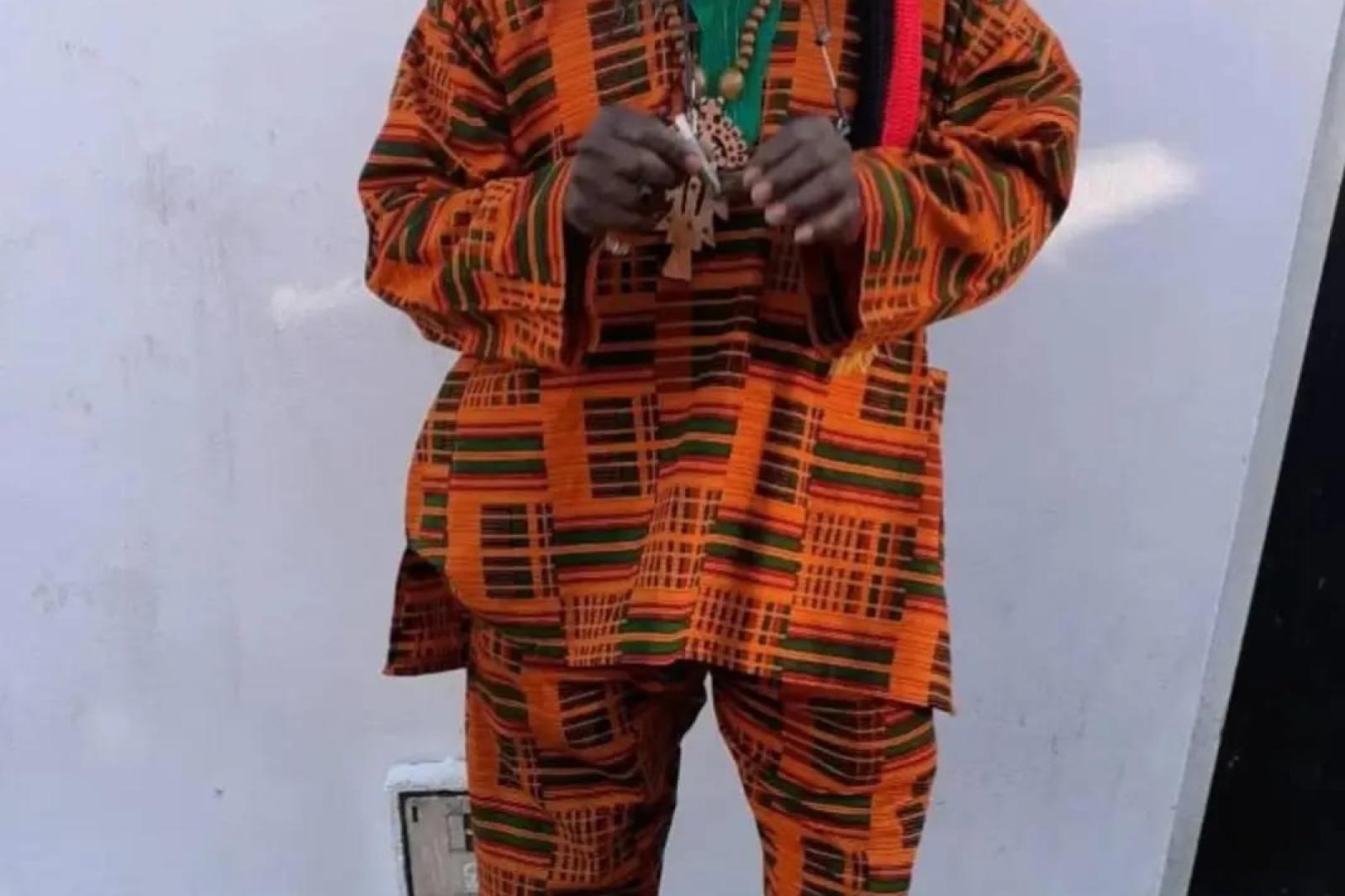 Fyah Mawi indoors wearing an orange patterned outfit and hat.