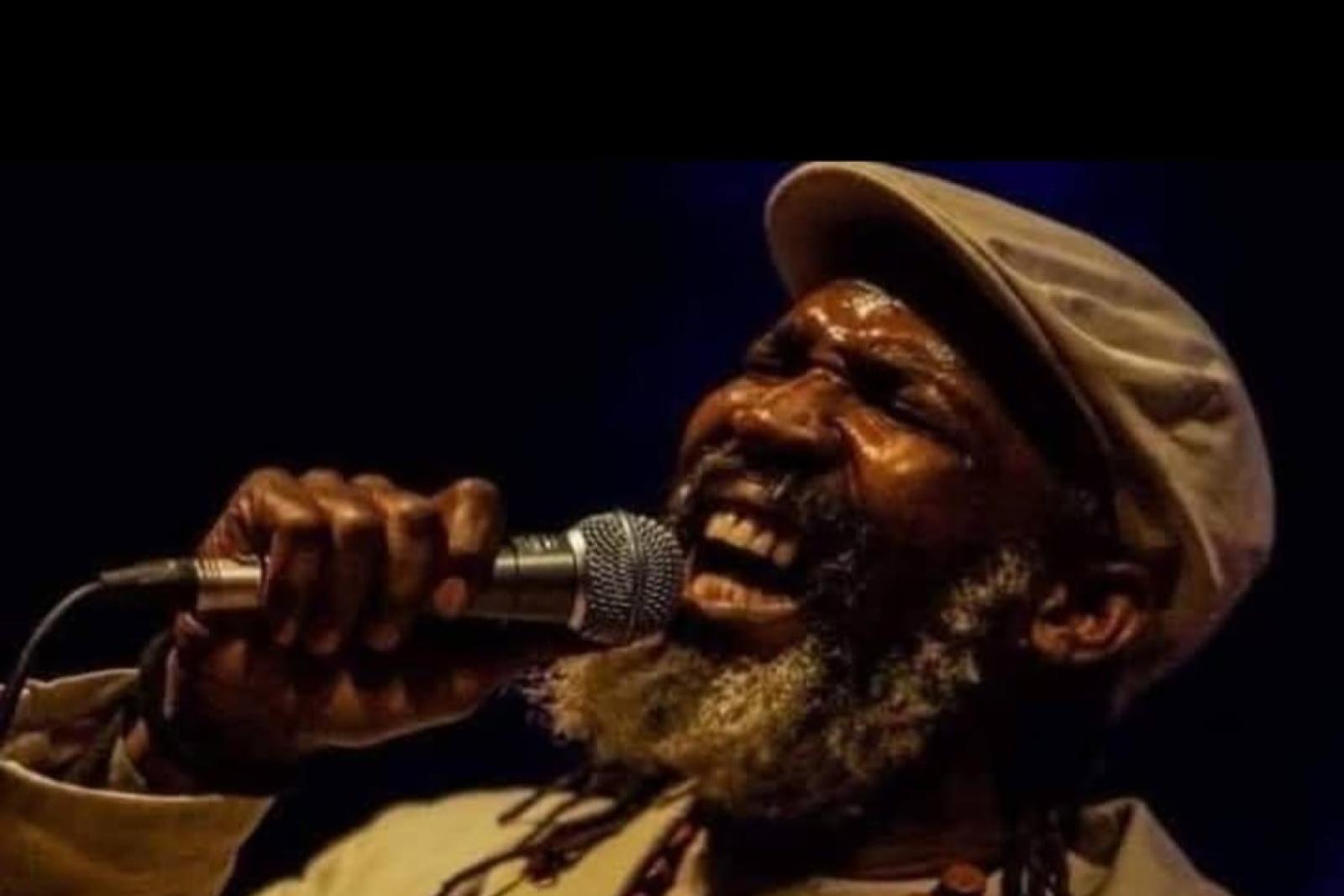 Fyah Mawi singing into a microphone on stage.