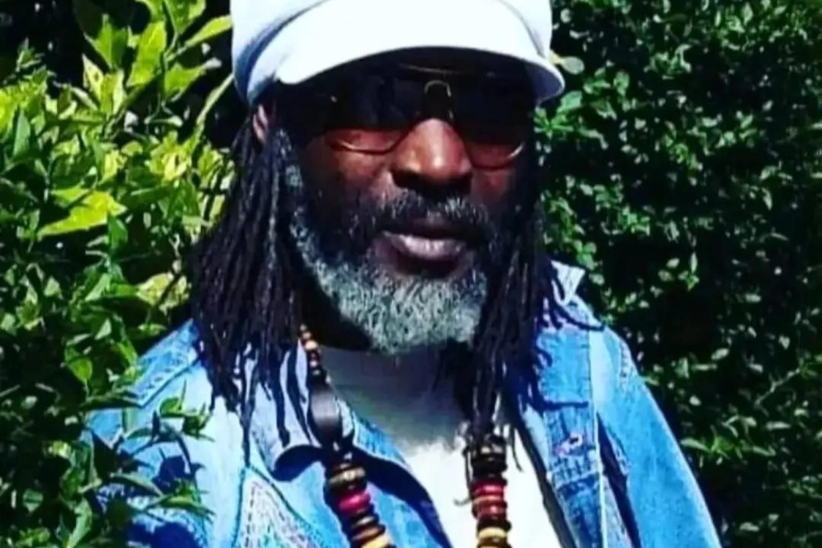 Portrait of Fyah Mawi wearing sunglasses and a white hat.