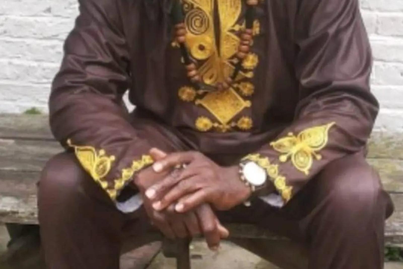 Fyah Mawi seated outdoors with long dreadlocks.