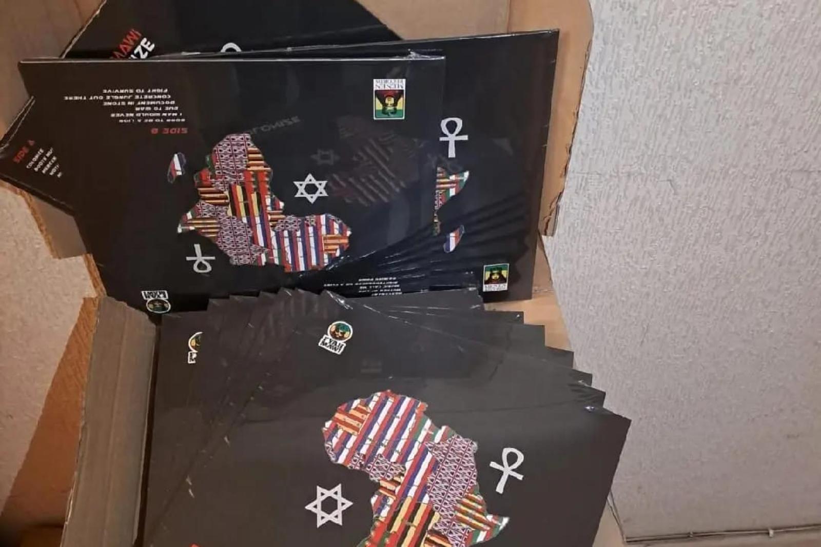 Fyah Mawi music releases and packaging arranged in an open box, view 3.